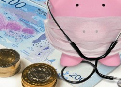 Billetes de 200 pesos, monedas y una alcancía con forma de chanchito