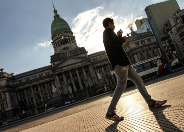 Hombre caminando frente a la fachada del Congreso